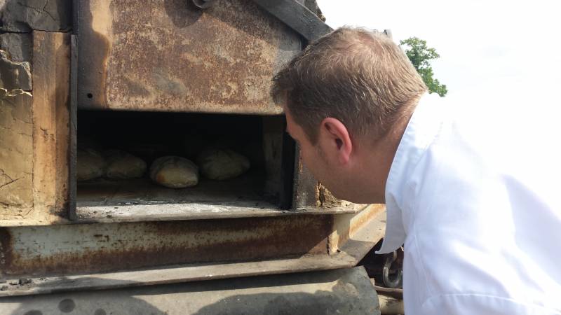 Monsieur Fanet cuisant les fameux Pains Normands dans un four à bois